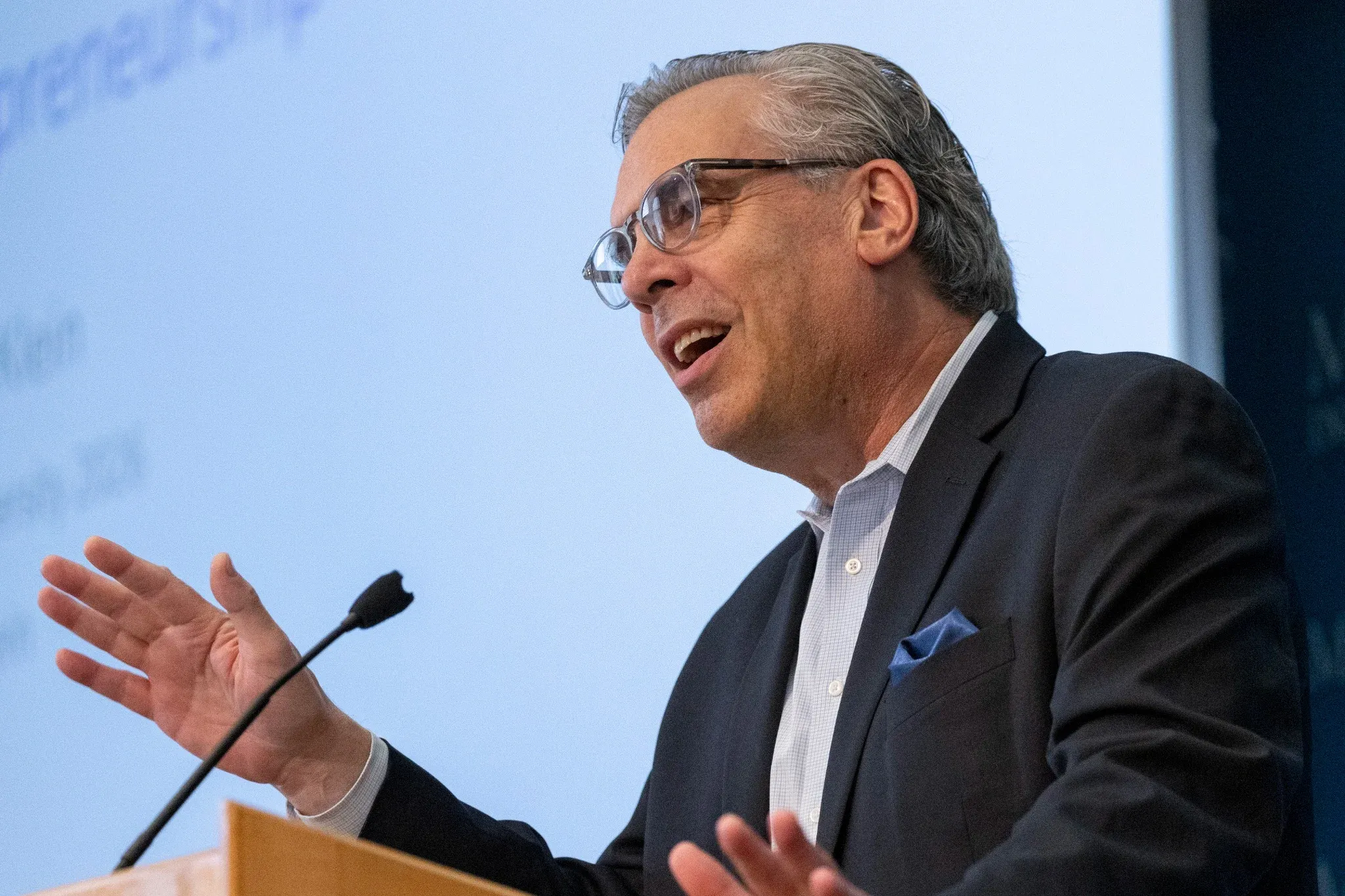 A scholar gesturing during a lecture